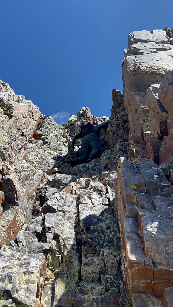 Randall climbing the chimney towards Trinity Peak