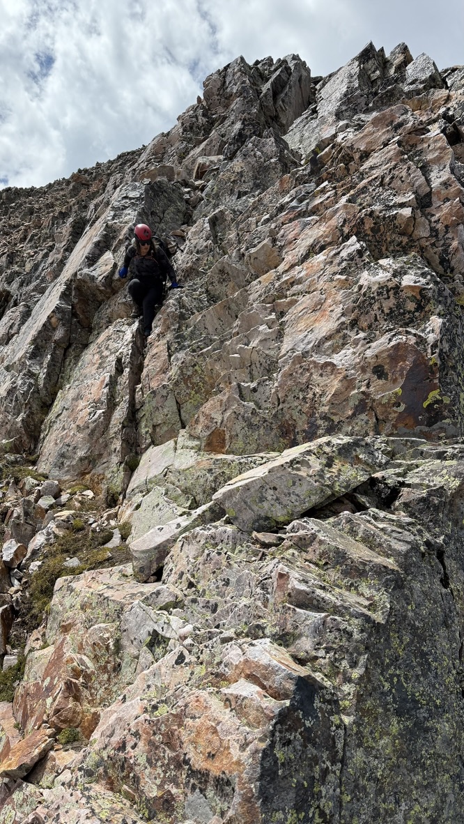 Maya climbing down a steep wall coming down from Trinity Peak
