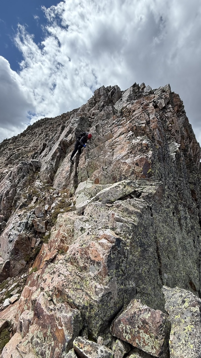 Maya climbing down a steep wall coming down from East Trinity Peak
