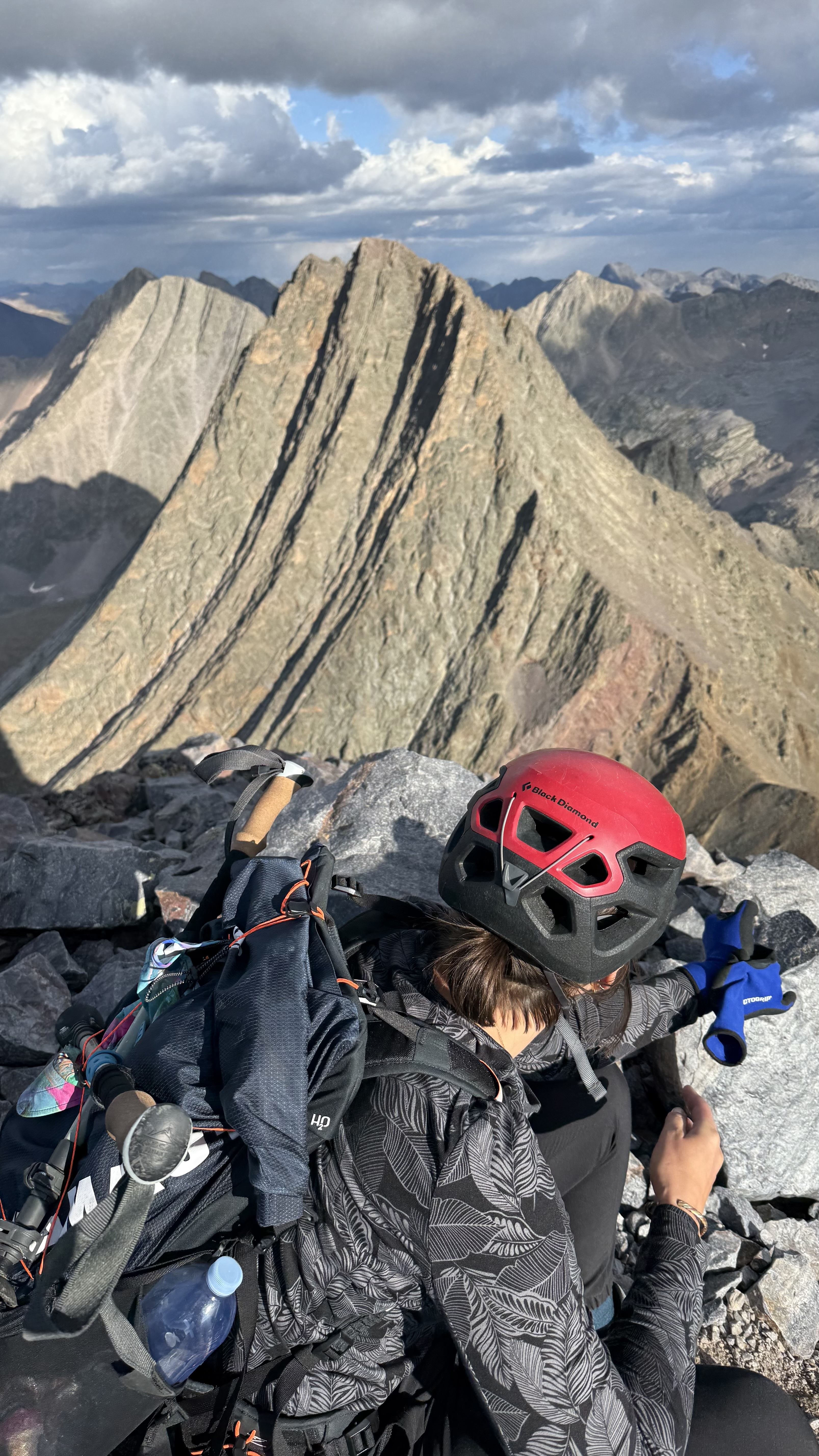 Maya on the summit of Arrow Peak looking at the intimidating Wham Ridge