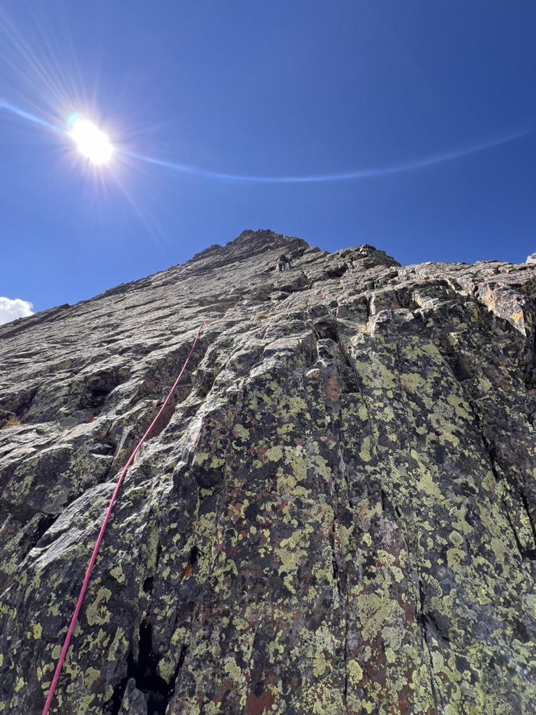 Randall climbing up the Wham Ridge as he places gear
