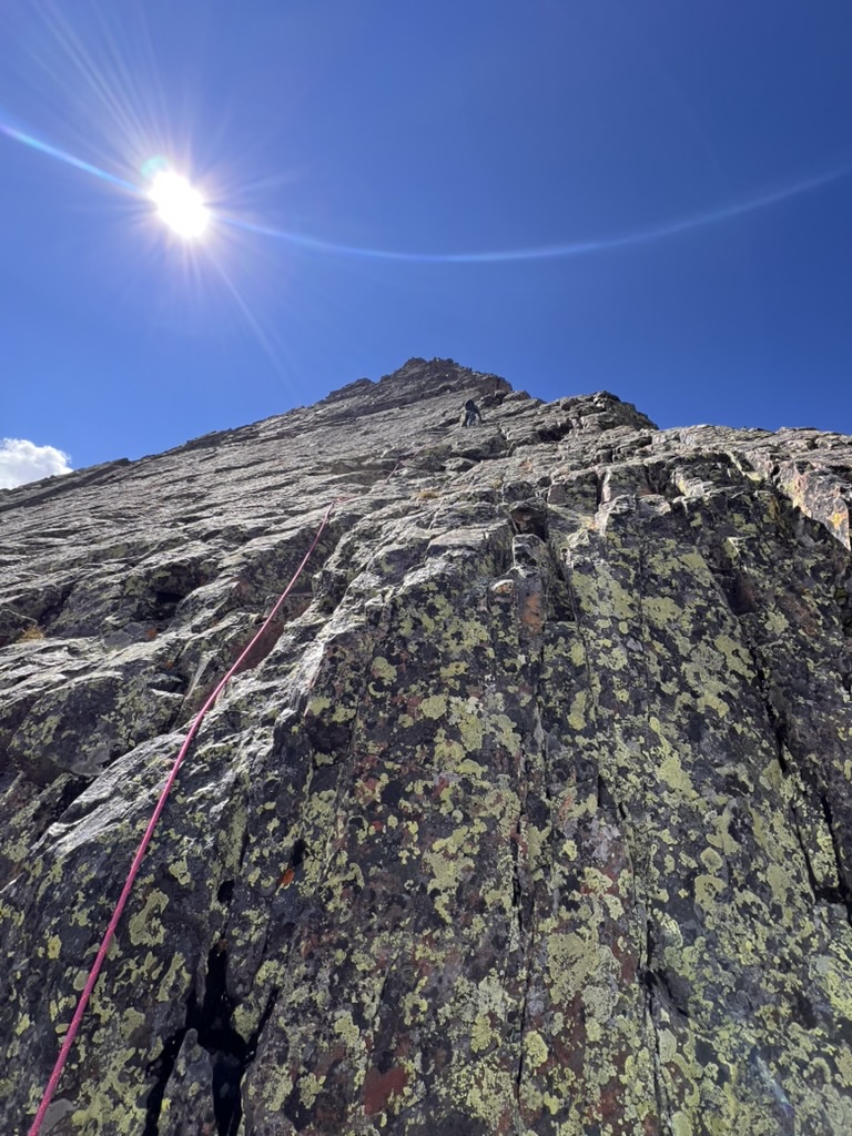 Randall climbing up the Wham Ridge as he places gear